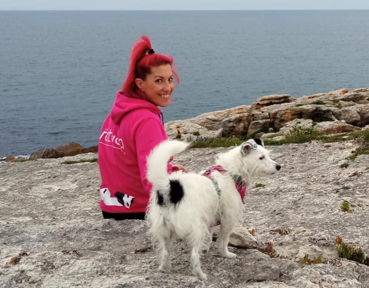 Educadora canina junto a su perra mirando el mar